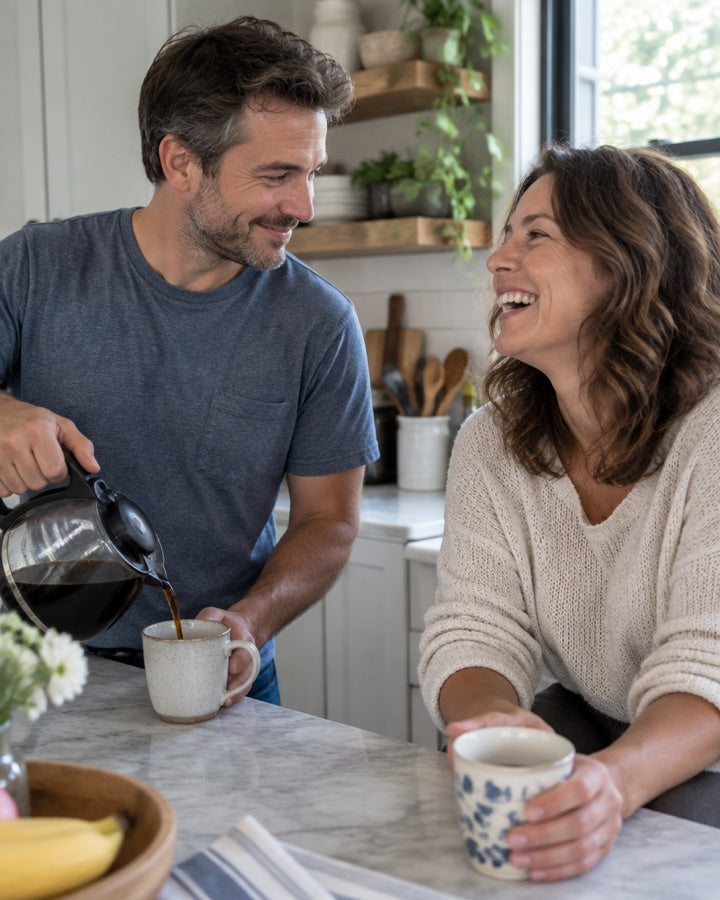 A couple laughing together over morning coffee
